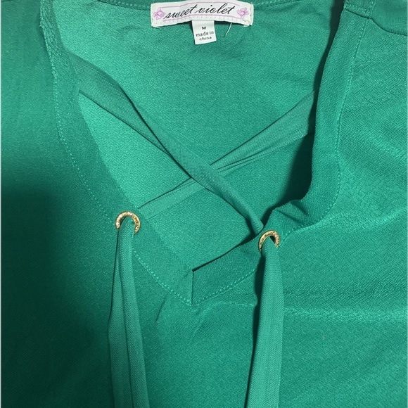 This is a green short-sleeved top with a V-neck design. - Picture 2 of 3